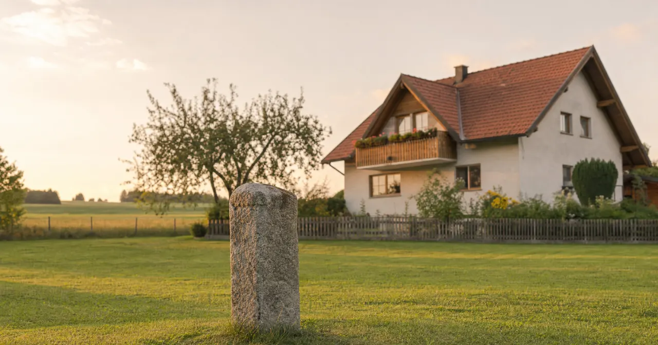 Einfamilienhaus mit Grenzstein am Rand des Grundstücks