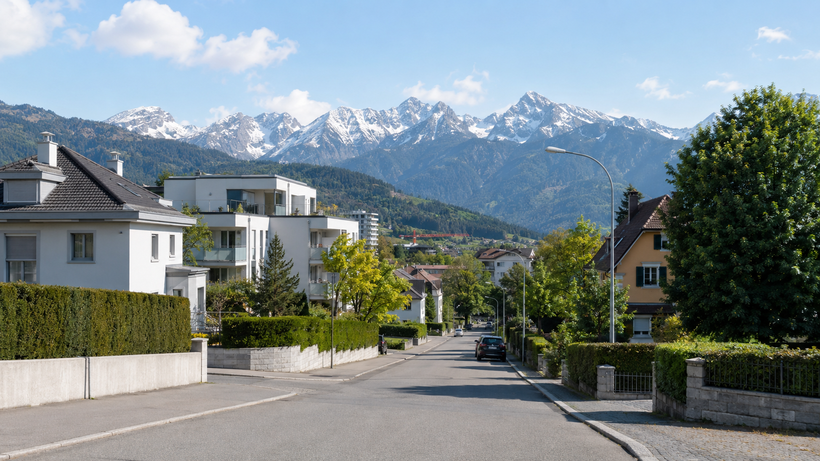 Wohnhäuser in einer österreichischen Landeshauptstadt mit Bergpanorama im Hintergrund